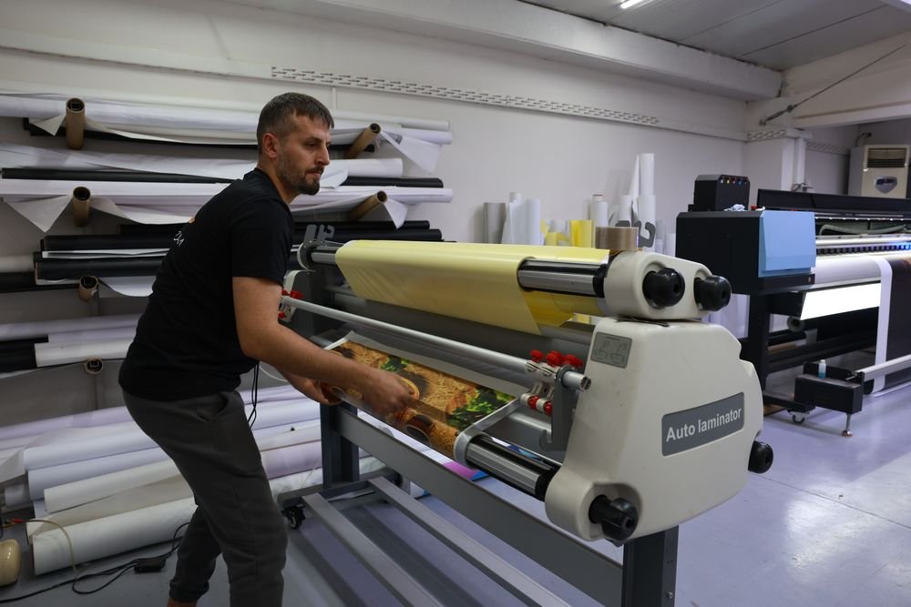 Say Reklam ekibi laminasyon makinesine baskıyı yerleştiriyor