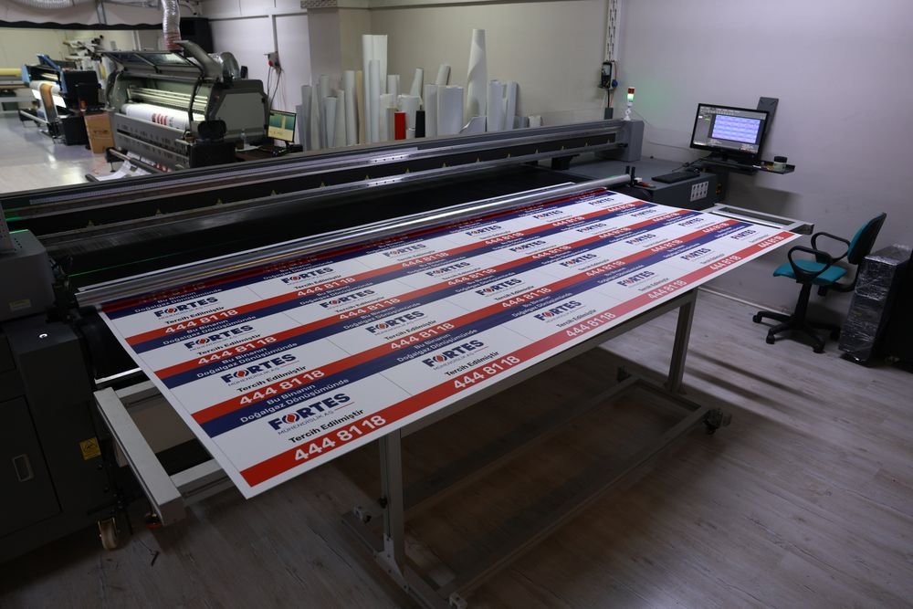 UV baskısı tamamlanan tabela panelleri baskı tablasında