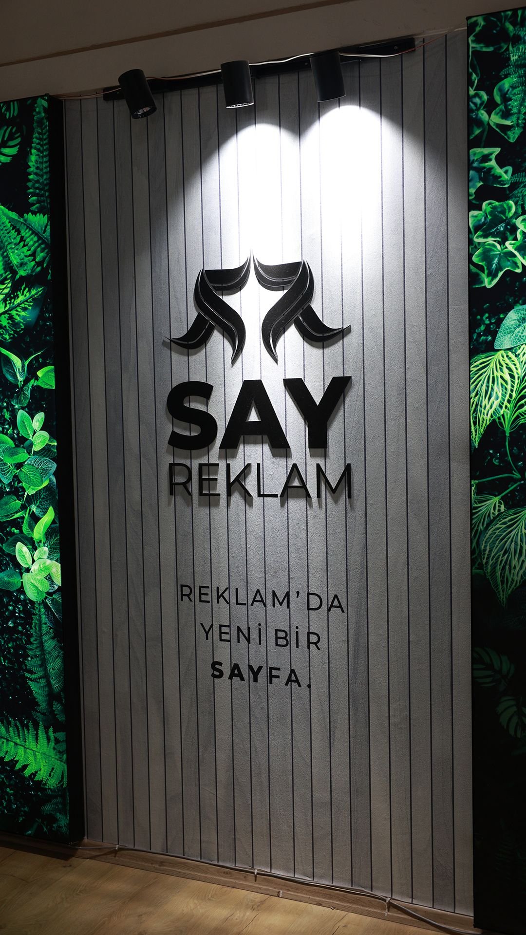 Say Reklam ofisinde 'Reklam'da yeni bir sayfa' yazılı logo duvarı