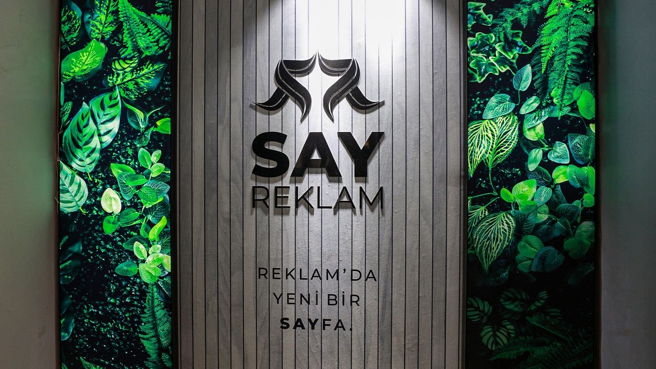 Say Reklam ofisinde 'Reklam'da yeni bir sayfa' yazılı logo duvarı